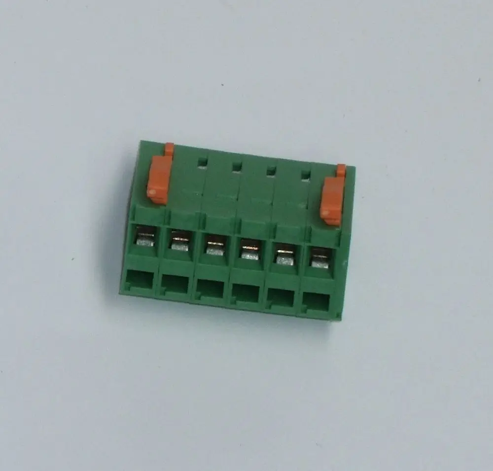 Grüner Anschlussstecker von Daikin mit mehreren Steckplätzen und orangefarbenem Hebel. Geeignet für elektrische Verbindungen.